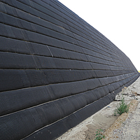 Fortrac Geogrid is installed next to a road on a wall for reinforcement and protection