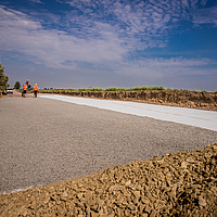 Workers on construction site laying Stabilenka geofabric