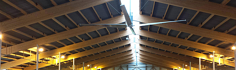 Several fans attached to the roof ridge of a barn