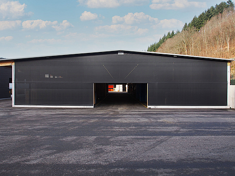 The front of the wooden storage unit is clad with a black Tectura clamping variant
